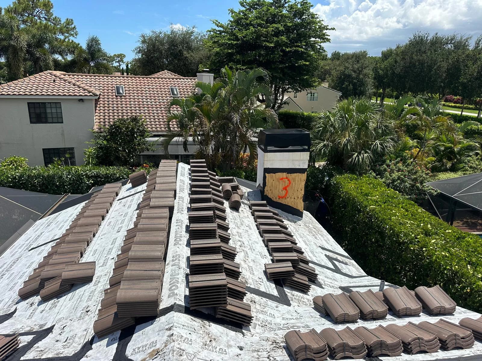 Barcelona 900 tile bundles staged around a chimney and roof transitions in Boca Raton