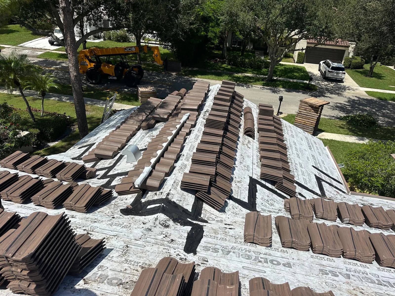 Barcelona 900 Chestnut Burnt concrete roof tile bundles staged across a Boca Raton roof