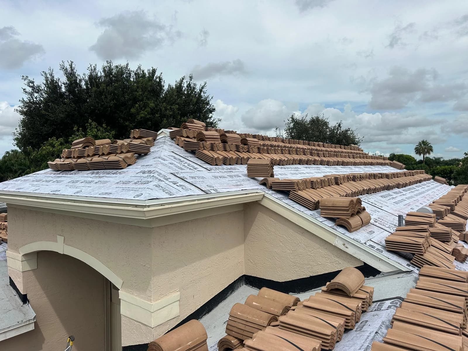 Estate roof tile bundles distributed across multiple roof planes at a Delray Beach-area home