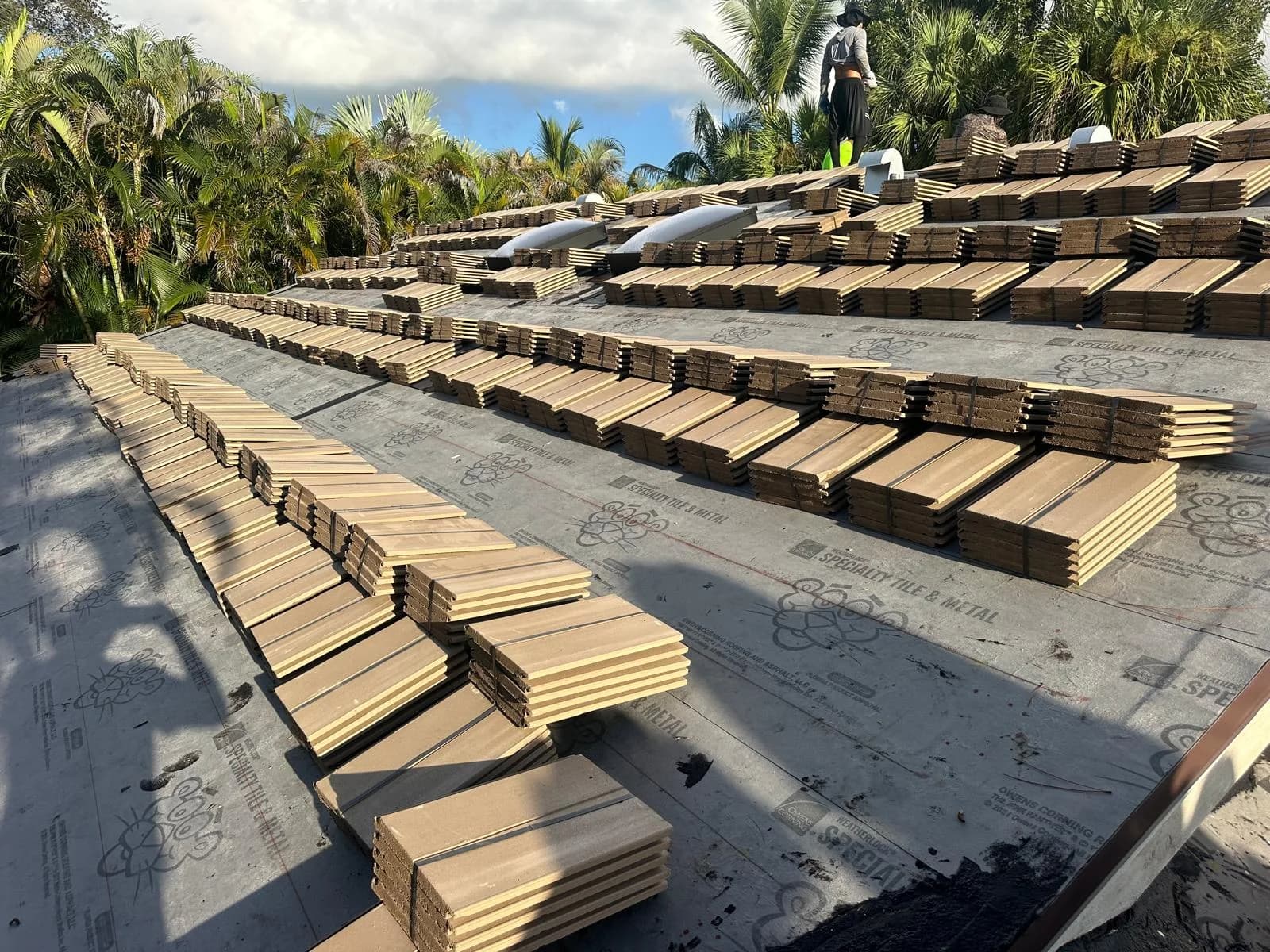 Roof tile bundles organized across a Jupiter roof while workers complete placement