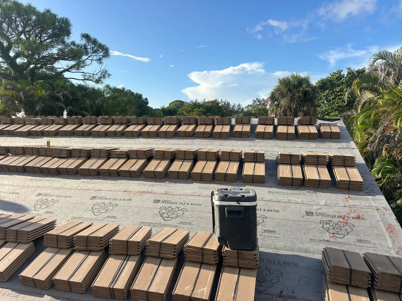 Concrete roof tile bundles arranged in rows across the prepared roof