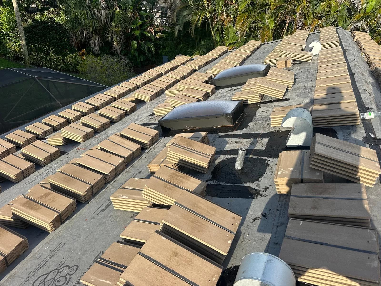 Concrete roof tile bundles positioned around roof vents on a Jupiter-area home