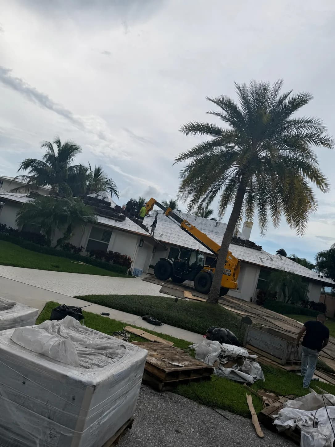 North Palm Beach rooftop crew receiving Madera 900 tile from a telehandler