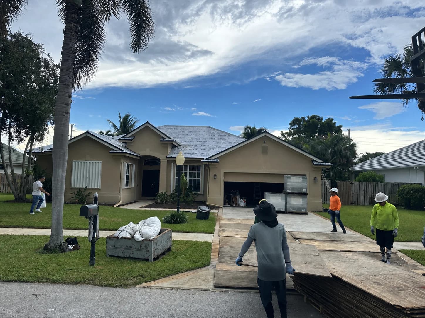MMJ crew preparing a plywood-protected Jupiter driveway for Saxony 900 roof tile delivery and rooftop loading