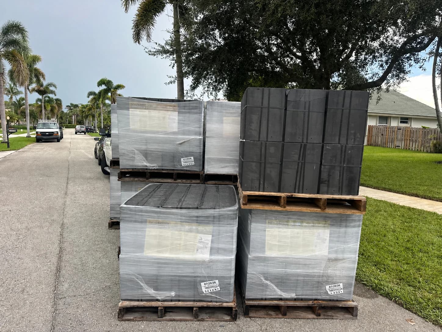Wrapped and unwrapped Saxony 900 pallets staged for a Jupiter roof tile delivery