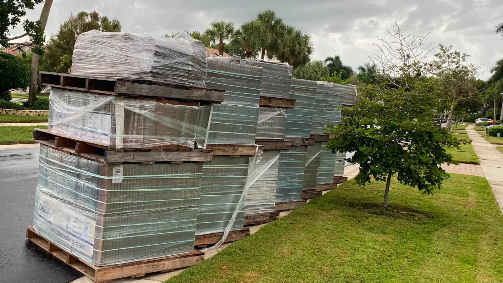 Wrapped roof tile pallets staged at a Florida delivery jobsite