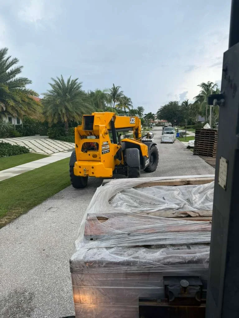 Telehandler beside wrapped Madera 900 pallets at a North Palm Beach roof tile delivery