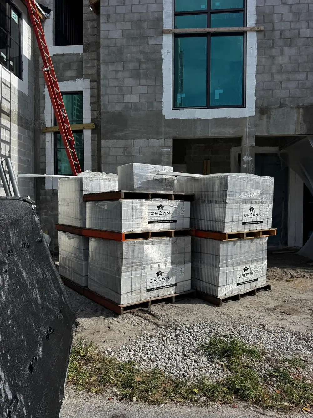 Protected roof tile pallets staged for a Florida roofing crew